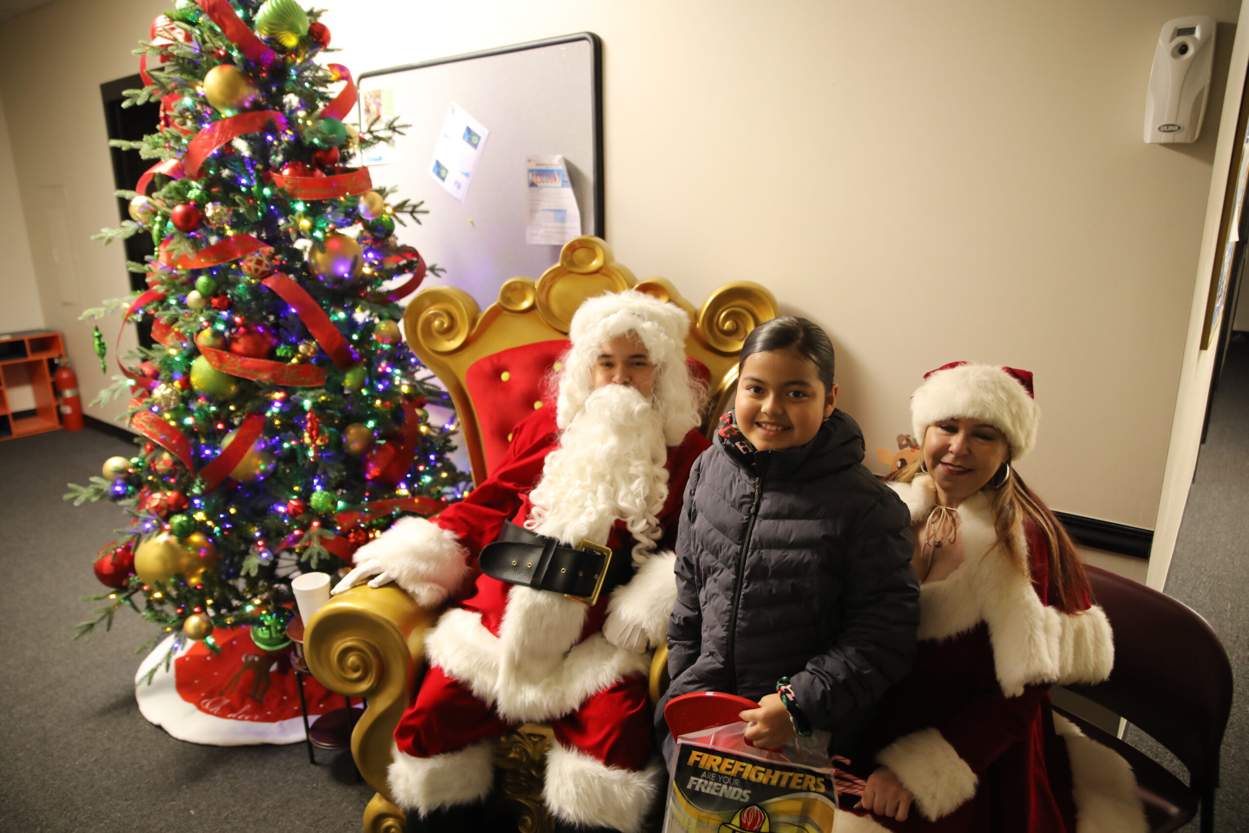 A family poses with Santa during the Town of Cicero gift giveaway event on Saturday Dec. 16, 2023.